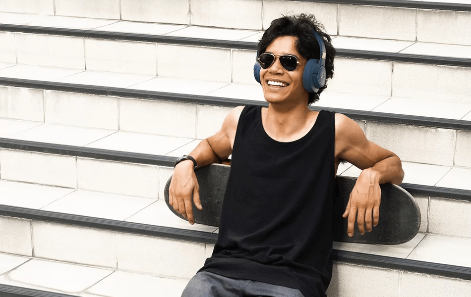 Jovem ouvindo música no fone JBL