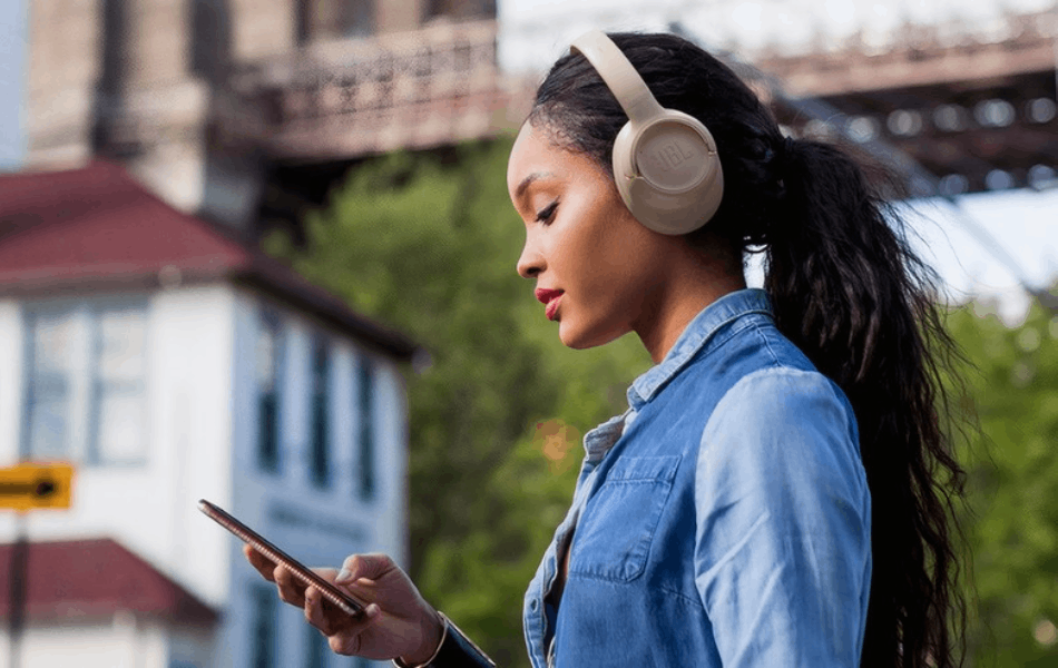Mulher ouvindo música no fone JBL